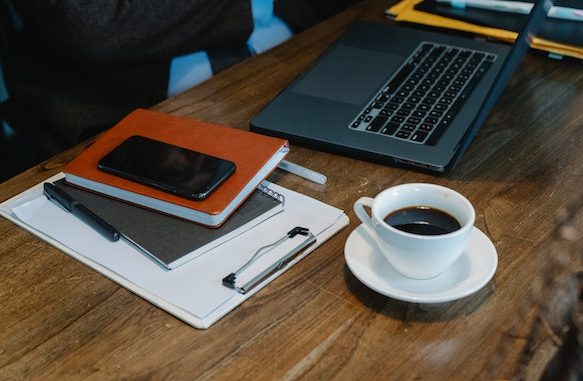 Laptop, coffee cup and binders on a desk