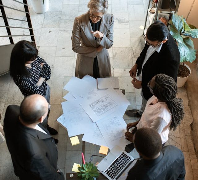 executives standing around table with papers