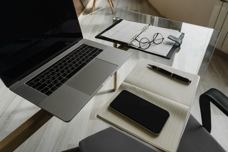 office desk with laptop and journals